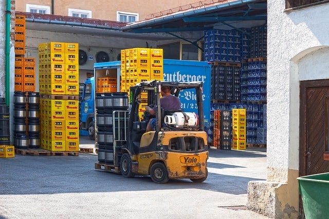 worker driving forklift in a brewery